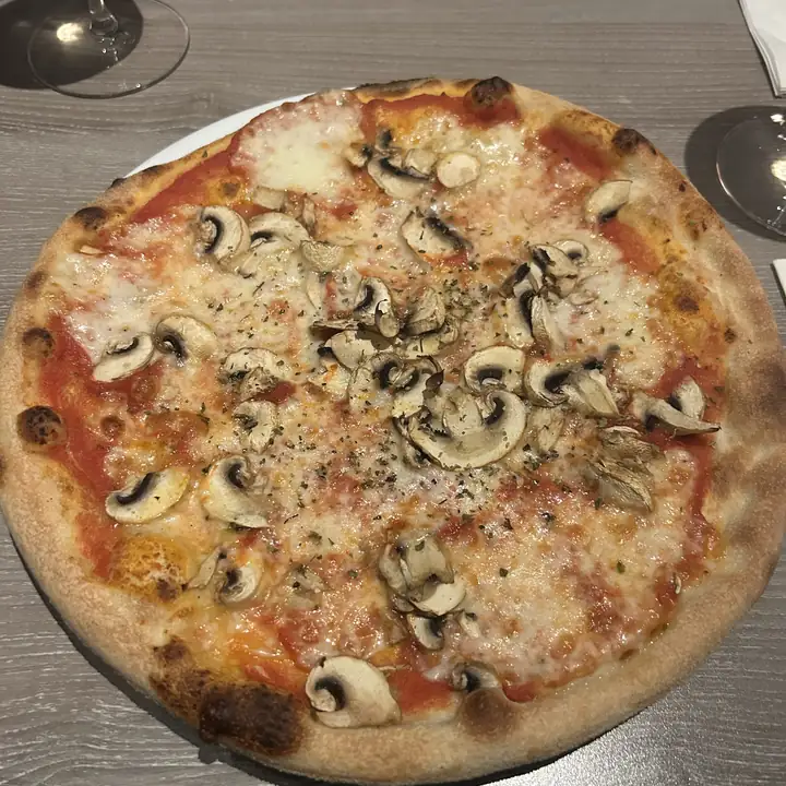 Pizza met champignons op een houten tafel